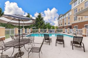 a patio with tables and chairs and a pool at Hilton Garden Inn Aiken in Aiken