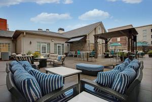 eine Terrasse mit Stühlen und Tischen auf einer Terrasse in der Unterkunft Homewood Suites Charlotte Ayrsley in Charlotte