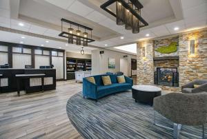 a lobby with a blue couch and a fireplace at Homewood Suites Charlotte Ayrsley in Charlotte