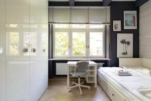 una camera da letto con scrivania, letto e finestra di Spacious 3BR apartment with AC in living room, 2 balconies a Cracovia