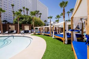 un complexe doté d'une piscine avec des lits et des parasols dans l'établissement Tropicana Las Vegas a DoubleTree by Hilton Resort & Casino - Free Parking, à Las Vegas