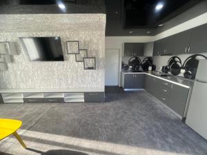 a kitchen with gray cabinets and a tv on the wall at La Mara luxuri apartament 