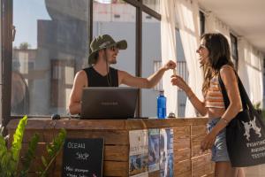 a man and a woman standing at a table with a laptop at Ocean Nomads Coworking in Arona