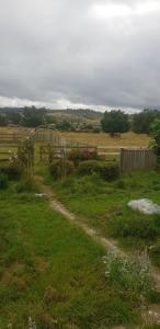 un camino de tierra en un campo con una valla en Ashmore Park en Armidale