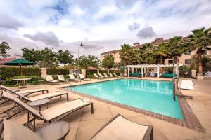 a swimming pool with lounge chairs and a hotel at Homewood Suites by Hilton Oxnard/Camarillo in Oxnard