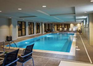 a large pool in a hotel with chairs around it at Hampton Inn & Suites/Foxborough/Mansfield in Foxborough