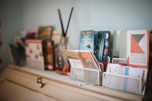 a shelf with books on top of a dresser at Villa Valentina Versilia in Viareggio