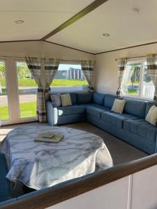 a living room with a blue couch and a table at luxury caravan in Tattershall