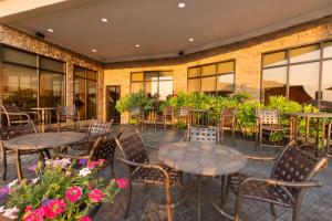 un patio con mesas, sillas y flores en Hilton Garden Inn Cartersville, en Cartersville