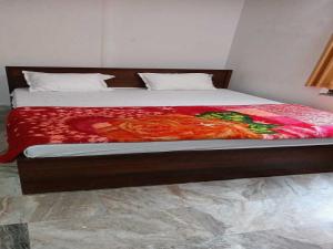 a bed with a red blanket on top of it at OYO Hotel K2 in Bihta