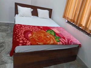 um quarto com uma cama com um cobertor vermelho em OYO Hotel K2 em Bihta