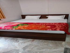 Una cama con un edredón rojo encima. en OYO Hotel K2 en Bihta