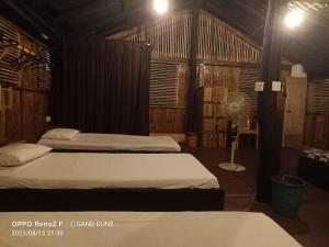2 camas en una habitación con ventilador en Sand Dune Beach Resort & Surf Camp, en Arugam Bay