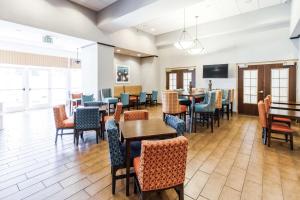 a dining room with tables and chairs and a tv at Hampton Inn & Suites Huntsville Hampton Cove in Huntsville