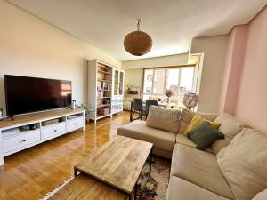 a living room with a couch and a flat screen tv at A Estancia das Mercedes in Ourense