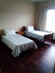two beds in a hotel room with a window at Despatch Self Catering Apartments in Despatch