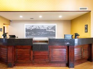 a hotel lobby with a reception desk with a laptop at Hampton Inn & Suites Salt Lake City Airport in Salt Lake City