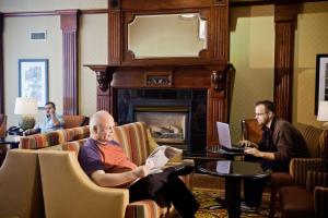 un gruppo di uomini seduti in una stanza con camino di Hampton Inn & Suites Salt Lake City Airport a Salt Lake City