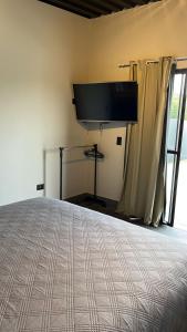 um quarto com uma cama e uma televisão de ecrã plano em CHALÉS SÃO ROQUE em São Roque