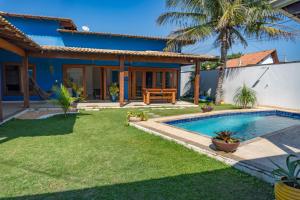 a backyard with a swimming pool and a house at Linda casa com piscina em Interlagos Vila Velha ES in Vila Velha