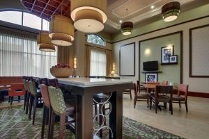 a restaurant with a bar and tables and chairs at Hampton Inn & Suites Spartanburg-I-26-Westgate Mall in Spartanburg