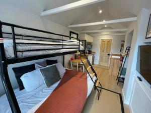 a bedroom with two bunk beds and a kitchen at Merryfield Lodge in Kent