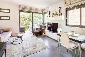 Luxury Oasis Tel Aviv Beach في تل أبيب: غرفة معيشة مع طاولة وكراسي وأريكة