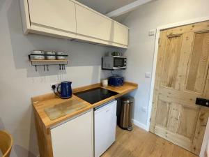 een kleine keuken met een wastafel en een aanrecht bij Merryfield Lodge in Kent