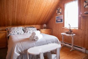 Un dormitorio con una cama con un osito de peluche. en Bed & café Petit Papillon, en Grandes-Bergeronnes