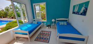 1 dormitorio con cama y pared azul en Villa Laonari, en Tsadha