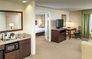 a hotel room with a bathroom with a bed and a television at Hilton Garden Inn Eugene/Springfield in Springfield