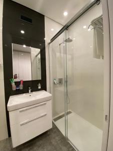 a bathroom with a white sink and a shower at North Avenue Modern Apartments in Yerevan