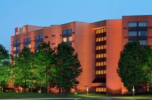 莱尔DoubleTree by Hilton Lisle Naperville的前面有树木的红砖建筑