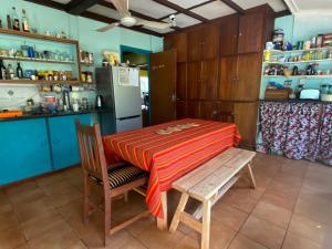 a kitchen with a table and a chair and a refrigerator at Thathe Dam Lodge in Vhutandabos