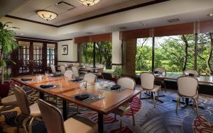 a dining room with tables and chairs and windows at DoubleTree by Hilton Lisle Naperville in Lisle