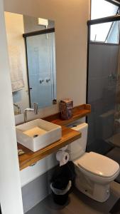 a bathroom with a sink and a toilet and a mirror at CHALÉS SÃO ROQUE in São Roque