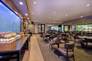 a restaurant with tables and chairs and a large window at DoubleTree by Hilton Pleasanton at The Club in Pleasanton