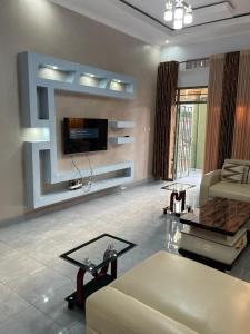 - un salon avec un canapé et une télévision dans l'établissement Best House Kimironko, à Kigali