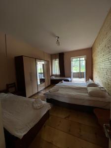 1 dormitorio con 2 camas y pared de ladrillo en Mushkudiani Manor, en Mestia