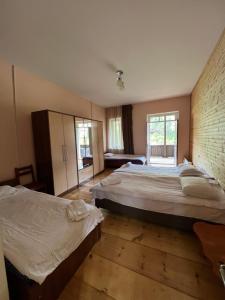 1 dormitorio con 2 camas y pared de ladrillo en Mushkudiani Manor en Mestia