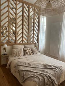 een slaapkamer met een groot bed en een houten muur bij Le Grenier à Sel in Châlons-en-Champagne