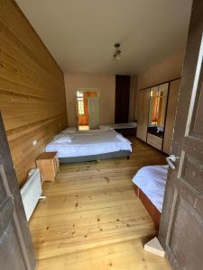 a large room with two beds and a wooden floor at Mushkudiani Manor in Mestia