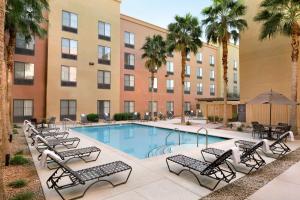 a swimming pool with chairs and a hotel at Homewood Suites by Hilton Las Vegas Airport in Las Vegas