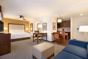 ラスベガスにあるホームウッド スイーツ バイ ヒルトン ラスベガス エアポートのベッドとリビングルームが備わるホテルルームです。