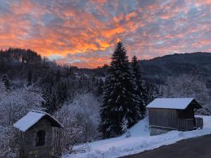 a winter sunset with a cabin in the snow at The Hideaway in Les Gets