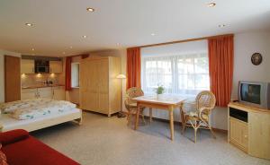 a bedroom with a bed and a table and a television at Gästehaus Bliem in Ainring