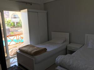 a small bedroom with a bed and a balcony at Sea View -SunnyDahab Resort in Dahab