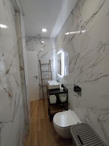 La salle de bains blanche est pourvue de toilettes et d'un lavabo. dans l'établissement T2 - Praia Pescadores Frente Mar - Casas & Papéis, à Armação de Pêra