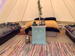 a room with a bed and a table in a tent at West Holme Glamping in Wareham