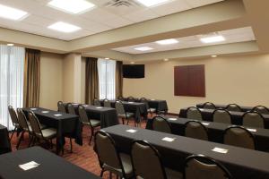 une salle de conférence avec des tables et des chaises noires et un podium dans l'établissement Hampton Inn & Suites Port St. Lucie, à Port Sainte-Lucie